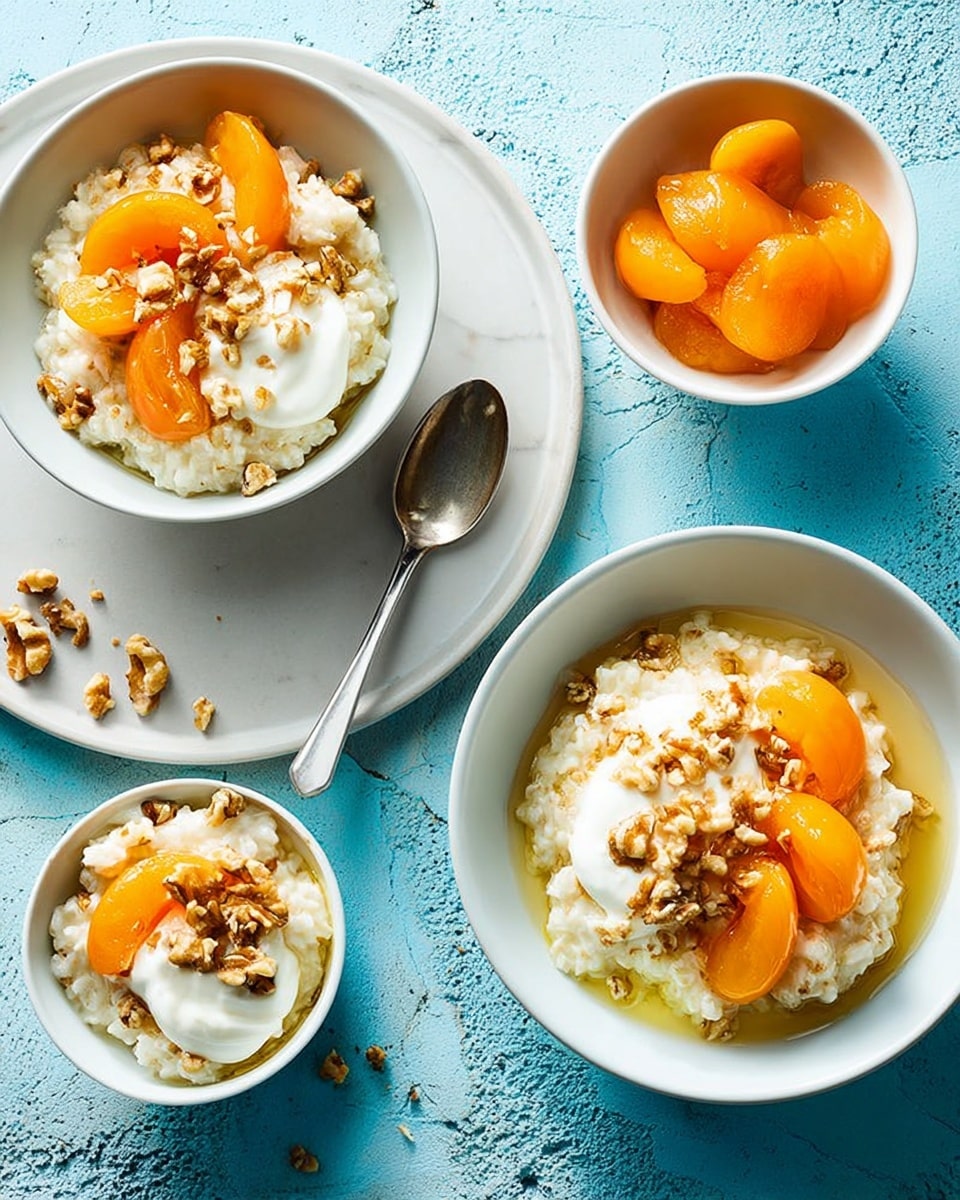 The image shows three white bowls filled with creamy rice pudding topped with dollops of white cream, orange apricot slices, and scattered brown walnut pieces. Two silver spoons rest inside two of the bowls, and one silver spoon lies on a large white plate that holds one of the bowls. Next to that bowl on the plate is a small white cup filled with more apricot slices in light syrup. Some walnut pieces are scattered on the plate and the white marbled surface below. The background is light blue with a soft texture. photo taken with an iphone --ar 4:5 --v 7