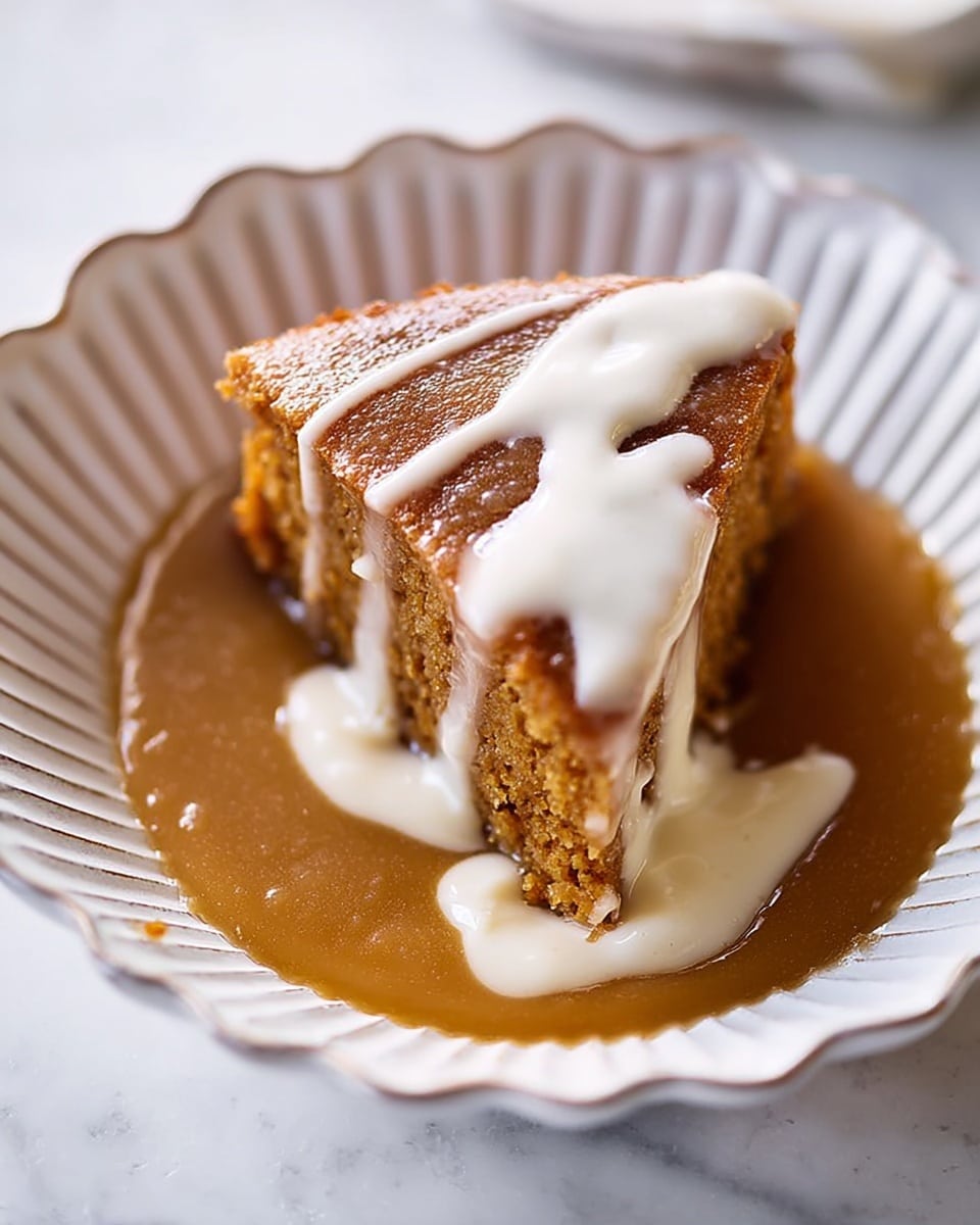 A slice of brown cake sits in a white, scalloped bowl with a rough, rustic texture. The cake has two visible layers: a dense, light brown base layer and a glossy, darker brown sauce layer covering the top and part of the sides. A creamy white sauce is drizzled over the top center of the cake, spreading slightly onto the darker sauce below. The bowl is placed on a white marbled surface, adding a clean and elegant contrast to the warm tones of the cake and sauces. Photo taken with an iphone --ar 4:5 --v 7