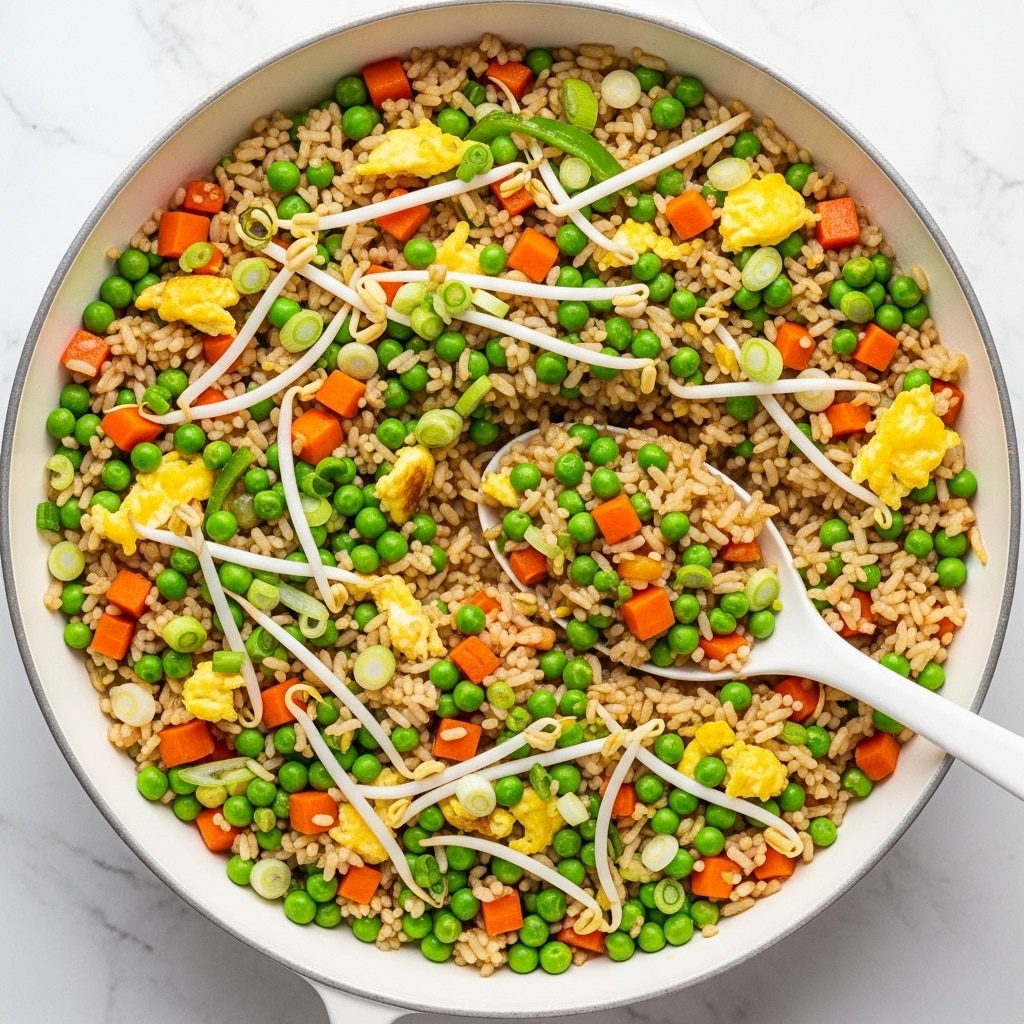 A white pan filled with fried rice featuring three main visible layers: a base of light brown cooked rice mixed with small green peas, bright orange diced carrots, and light yellow scrambled egg pieces, scattered evenly throughout; on top are fresh green sliced spring onions and light beige bean sprouts adding texture and color contrast; a white spoon scoops a portion, showing the mix of ingredients close up with a white marbled surface underneath. photo taken with an iphone --ar 4:5 --v 7