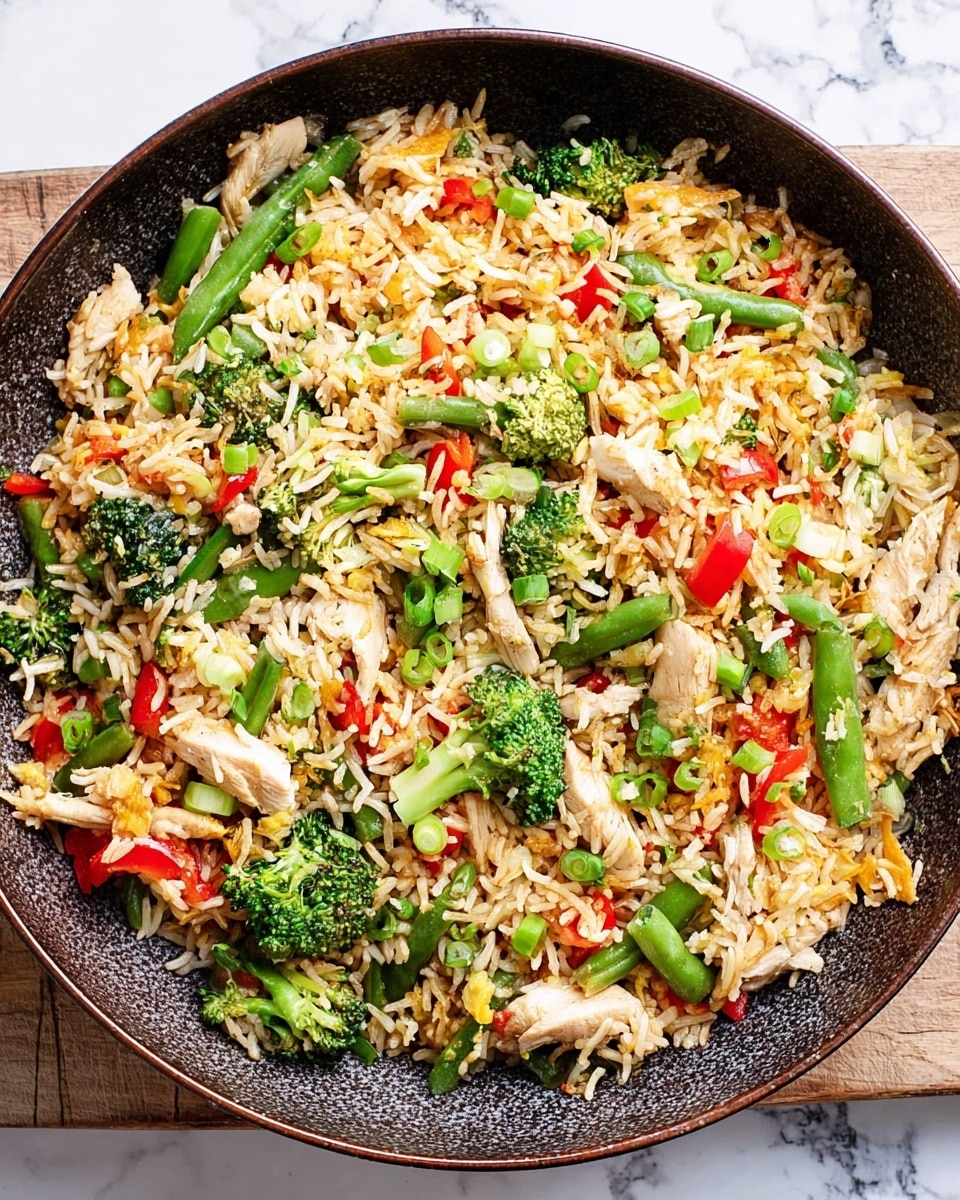 The image shows a large round pan filled with fried rice mixed with pieces of green broccoli, red bell pepper, light yellow scrambled eggs, and sliced green onions, all sprinkled with sesame seeds. The rice is light brown and fluffy, forming the base layer. Bright green broccoli florets and green beans with a fresh, crisp texture are spread evenly on top. Red bell pepper pieces add a pop of color scattered throughout. Light yellow scrambled egg pieces are mixed in, giving a soft texture contrast, and thin slices of green onions are laid on top, adding a fresh look. The pan is placed on a white marbled surface, with a corner of a white plate visible in the background. photo taken with an iphone --ar 4:5 --v 7