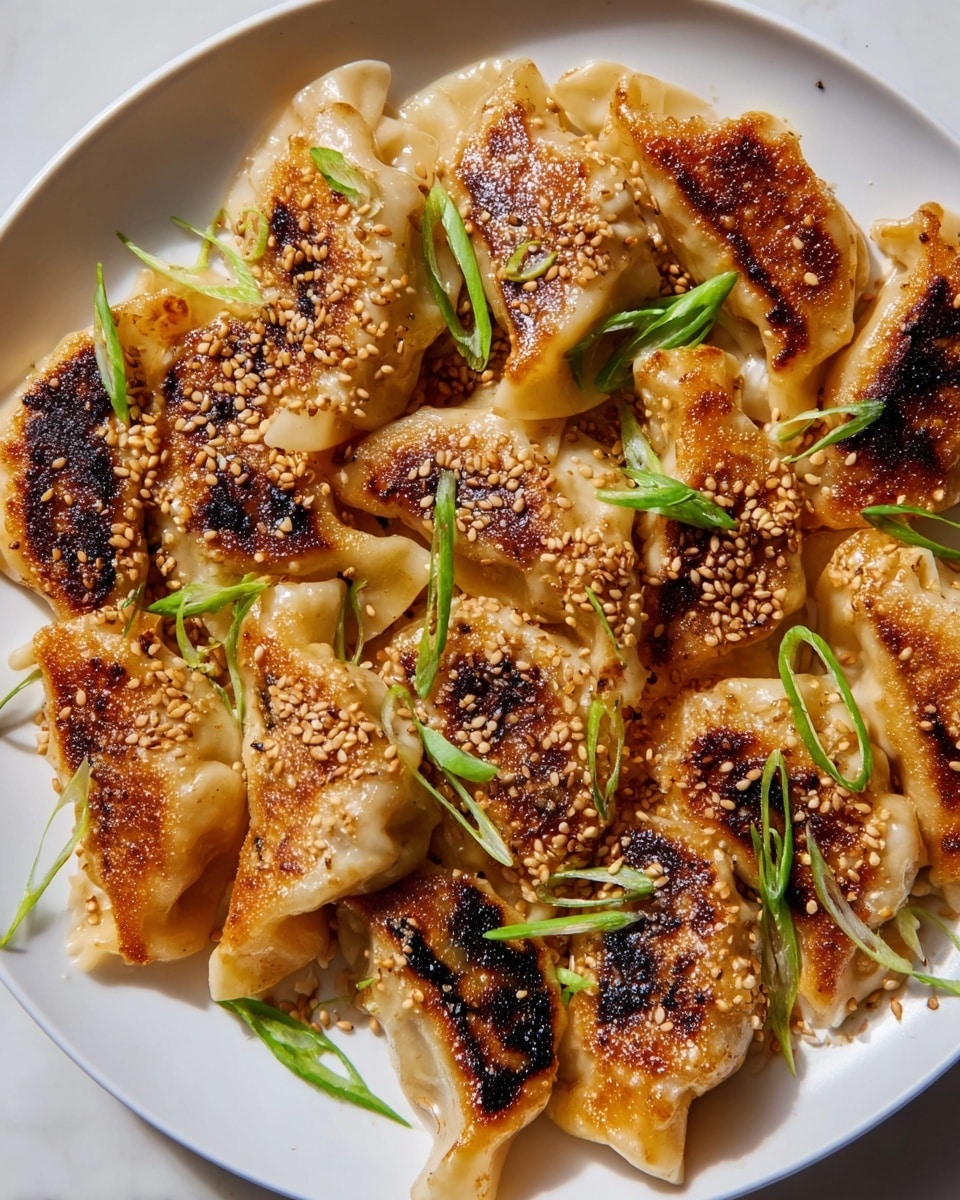 The image shows a white plate filled with one layer of golden-brown cooked dumplings, each dumpling having a slightly crispy and browned bottom texture. The tops and edges of the dumplings are soft and pale yellow in color with gentle folds. Scattered over the dumplings are toasted sesame seeds adding a light beige crunch. Bright green sliced scallions are sprinkled on top, providing a fresh color contrast to the warm tones of the dumplings. The plate rests on a white marbled surface. photo taken with an iphone --ar 4:5 --v 7