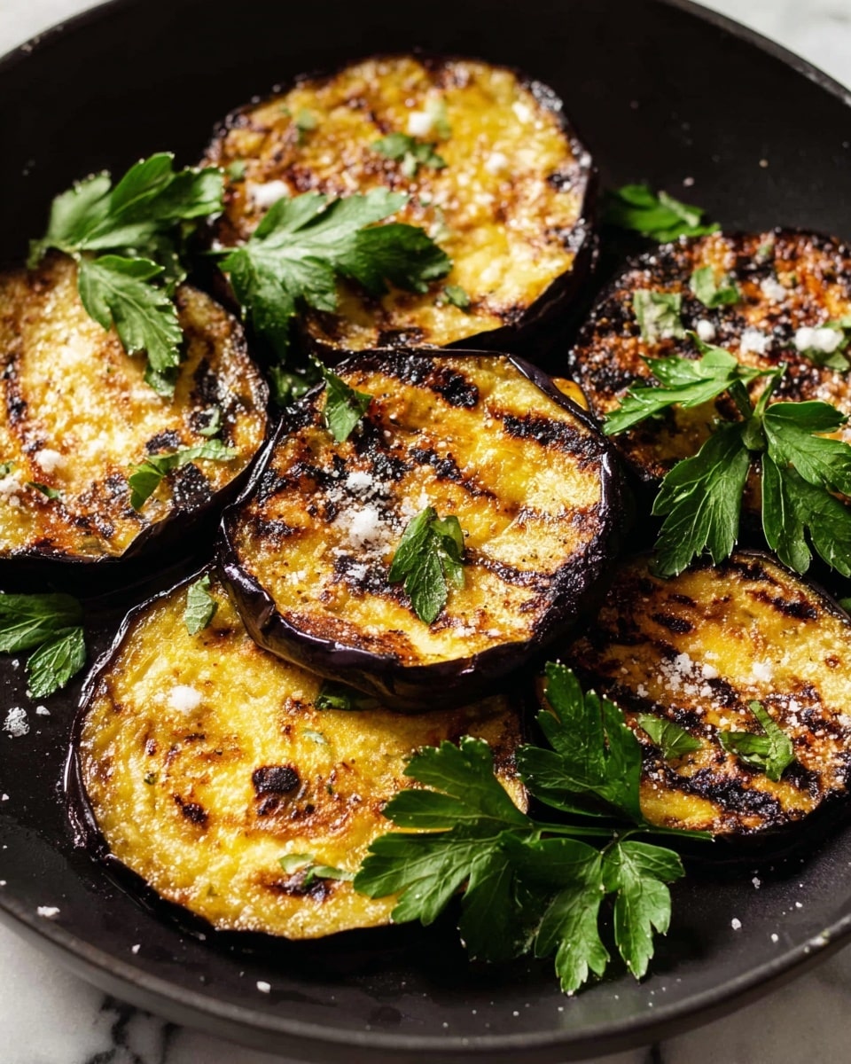 The image shows six pieces of grilled eggplant rounds arranged in a black pan, each slice showing a golden brown color with dark grill marks and a slightly charred texture. The eggplant slices have a soft, creamy center with a darker, crisped edge, and some are sprinkled with coarse sea salt. Bright green parsley leaves are scattered on and around the eggplant for a fresh contrast. The pan's black surface highlights the warm tones of the eggplant and the vibrancy of the parsley. photo taken with an iphone --ar 4:5 --v 7