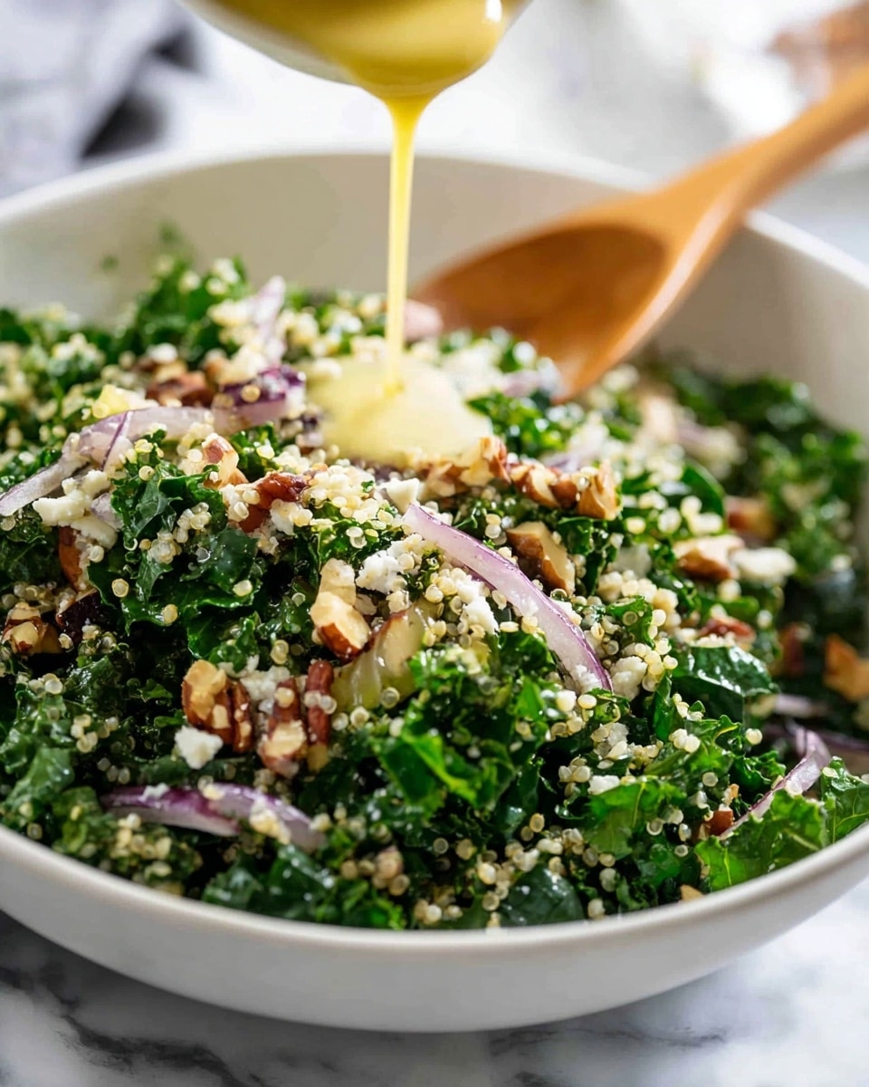 A close-up of a fresh salad in a white bowl set on a white marbled surface. The salad has layers including bright green kale leaves, pale beige cooked quinoa, small white crumbles of cheese, thin slices of light purple onion, and small pieces of chopped brown nuts scattered on top. A yellow dressing is being poured over the salad from a bottle held by a woman's hand, with the dressing creating a glossy texture on the greens and quinoa. photo taken with an iphone --ar 4:5 --v 7