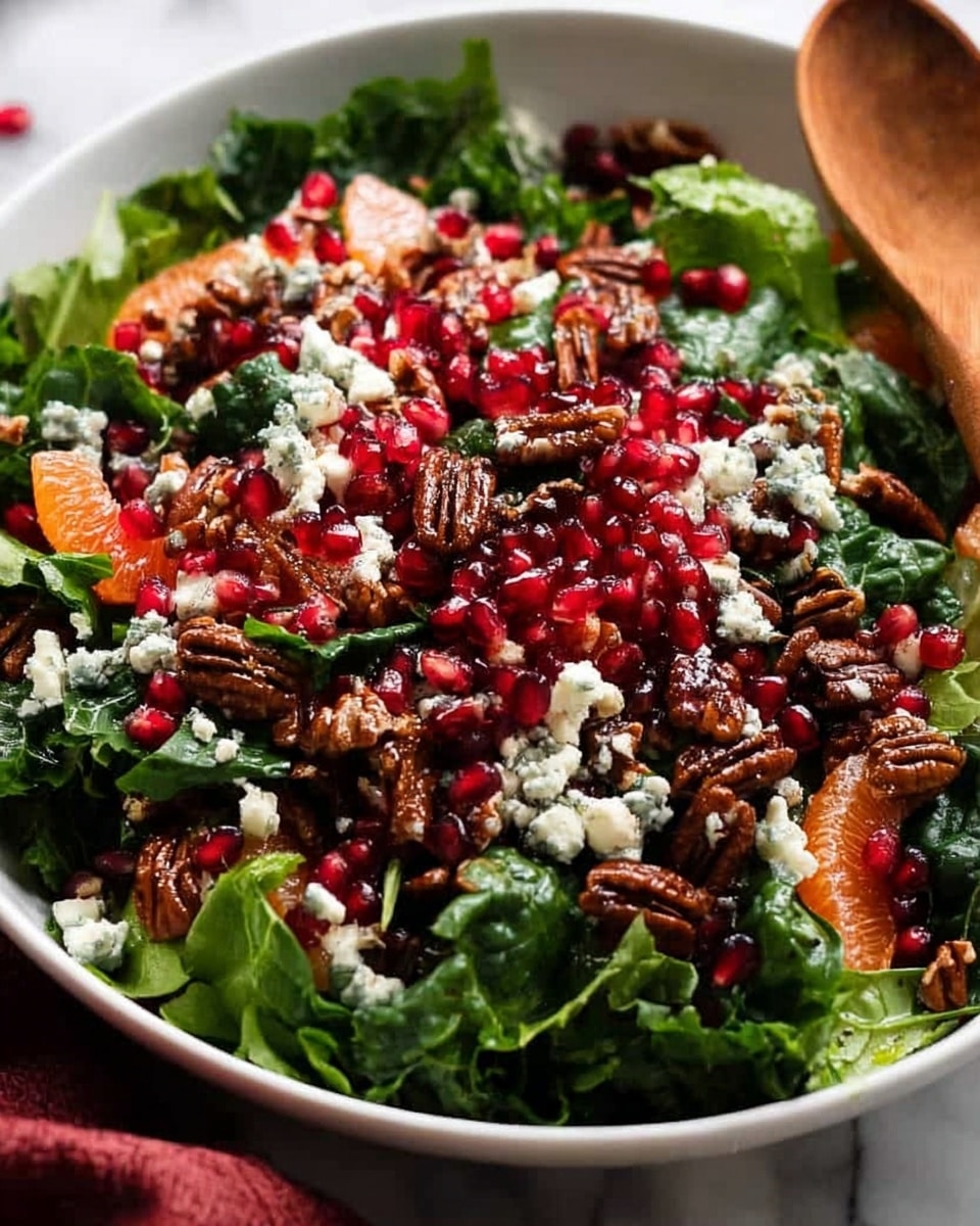 A white bowl filled with a fresh salad arranged in layers, starting with a base of dark green kale and lighter green spinach leaves. On top, there are bright red pomegranate seeds scattered all over, adding small pops of color. Orange segments are laid among the greens, adding a soft texture and bright orange tone. Crumbled white cheese with blue veins is sprinkled throughout, contrasting with the greens and reds. Brown pecans are mixed in, providing a crunchy texture. A wooden spoon rests inside the bowl, and the bowl sits on a white marbled surface with a red cloth slightly visible under the bowl. photo taken with an iphone --ar 4:5 --v 7